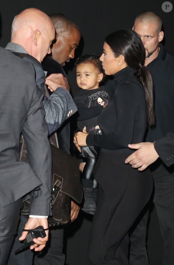 Kim Kardashian, son mari Kanye West et leur fille North au défilé Balenciaga prêt-à-porter collection printemps-été 2015 à Paris, le 24 septembre 2014.