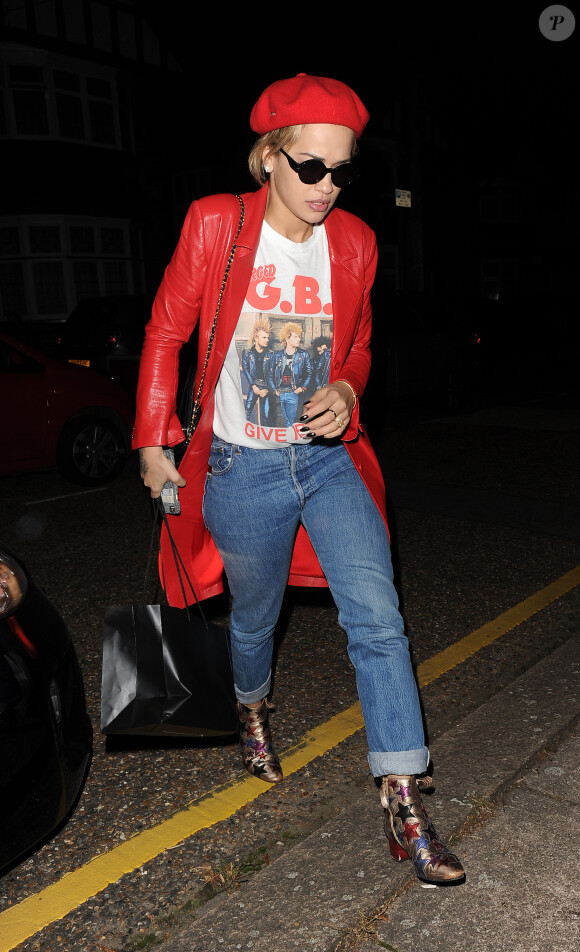 Rita Ora quitte un studio d'enregistrement à Londres, vêtue d'un manteau en cuir Melissa Pinkstone (collection printemps-été 2016), d'un t-shirt vintage à l'effigie du groupe GBH, d'un jean et de bottines Tommy Hilfiger. Un sac Chanel accessoirise sa tenue. Le 21 septembre 2016.