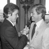 Alain Delon serre la main de Jean-Paul Belmondo quand celui-ci est récompensé à Paris en 1980