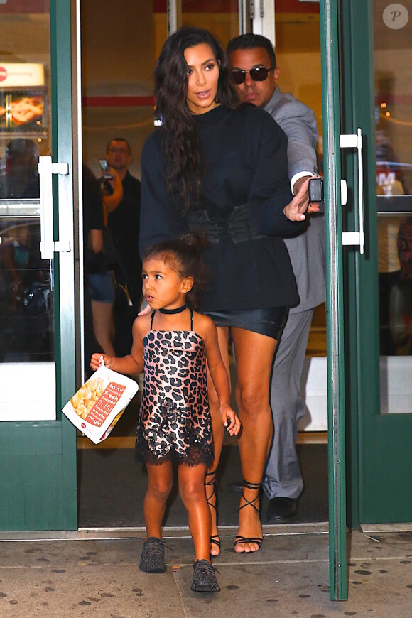 Kim Kardashian, son mari Kanye West et leur fille North à la sortie du cinéma AMC Movie Theater à New York, le 29 août 2016.