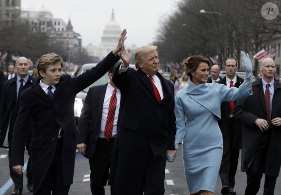Donald Trump salue la foule sur Pennsylvania Avenue avec sa femme Melania Trump et lerus fils Barron, le 20 janvier 2017.