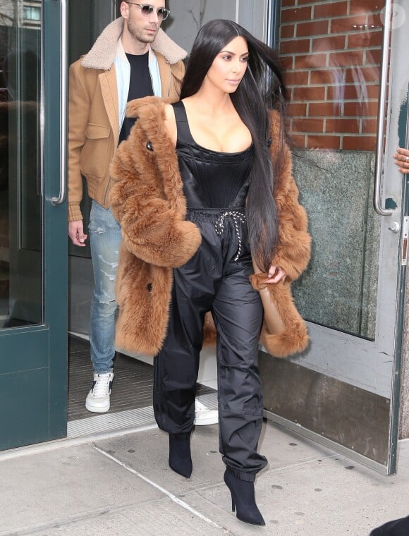 Kim Kardashian quitte son appartement à New York, vêtue d'un manteau en shearling Coach, d'un top bustier Vivienne Westwood, d'un pantalon adidas et de chaussures YEEZY. Le 16 février 2017.