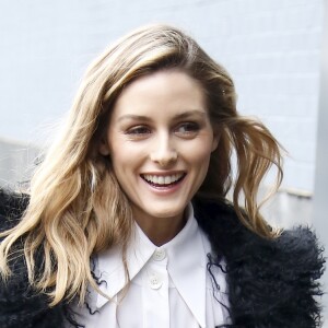 Olivia Palermo arrive au défilé Michael Kors Collection, habillée d'un manteau noir, d'une chemise, d'une jupe et d'une ceinture Michael Kors Collection (collection printemps 2017) et de chaussures Givenchy. New York, le 15 février 2017.