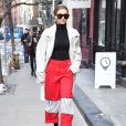 Gigi Hadid à New York, porte un trench-coat AMBUSH® (collection "Surplus Sound System"), un pull Wolford, un pantalon rouge et des chaussures Tony Blanco. Le 13 février 2017.