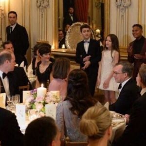 Le prince William et Kate Middleton observant les Kids United en train de chanter leur reprise du tube Happy lors du dîner de gala organisé le 17 mars 2017 à la résidence de l'ambassadeur de Grande-Bretagne à Paris, au premier soir de la visite officielle du duc et de la duchesse de Cambridge. Happy, l'une des chansons au son desquelles le prince William se déchaînait quelques jours plus tôt à Verbier...