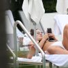 Ashley Graham se relaxe au bord d'une piscine avec son mari Justin Ervin à Miami, le 2 mars 2017 © CPA/Bestimage