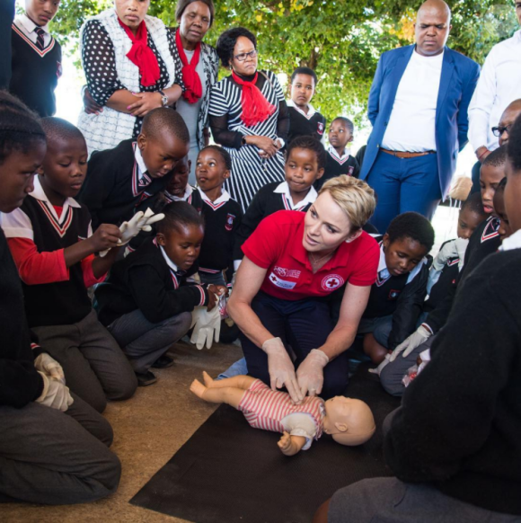 La princesse Charlene de Monaco montrant les gestes de premiers secours et de réanimation cardio-pulmonaire lors d'une visite ena vril 2017 à l'école primaire Gugulesizwe à Benoni en Afrique du Sud, où elle avait lancé en 2012 sa fondation. Photo Instagram officiel HSH Princess Charlene.