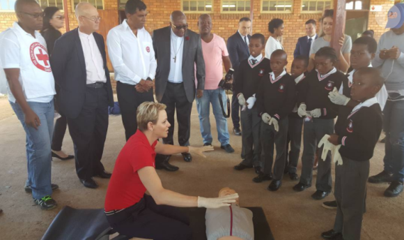 La princesse Charlene de Monaco montrant les gestes de premiers secours et de réanimation cardio-pulmonaire lors d'une visite à l'école primaire Gugulesizwe à Benoni en Afrique du Sud, où elle avait lancé en 2012 sa fondation. Photo Instagram @saredcross (Croix-Rouge sud-africaine)