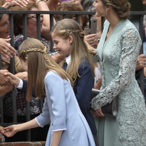 L'infante Sofia d'Espagne et la princesse Leonor des Asturies, avec leur mère la reine Letizia d'Espagne, saluent le public lors de la première communion de l'infante Sofia d'Espagne, le 17 mai 2017 à Madrid.