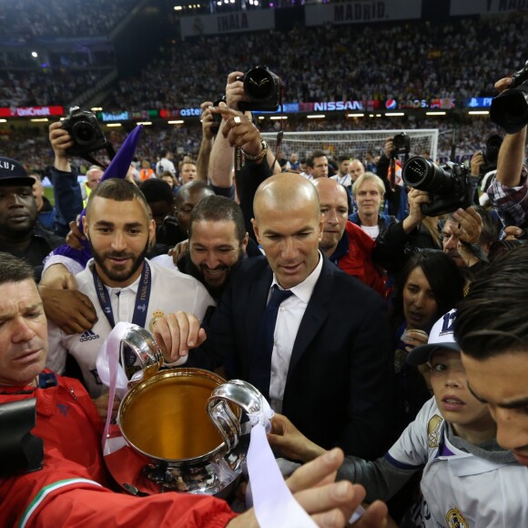 Zinedine Zidane avec ses fils Elyaz et Enzo (à sa gauche) et Karim Benzema (à sa droite) lors de la victoire du Real Madrid en finale de la Ligue des Champions contre la Juventus de Turin le 3 juin 2017 à Cardiff.