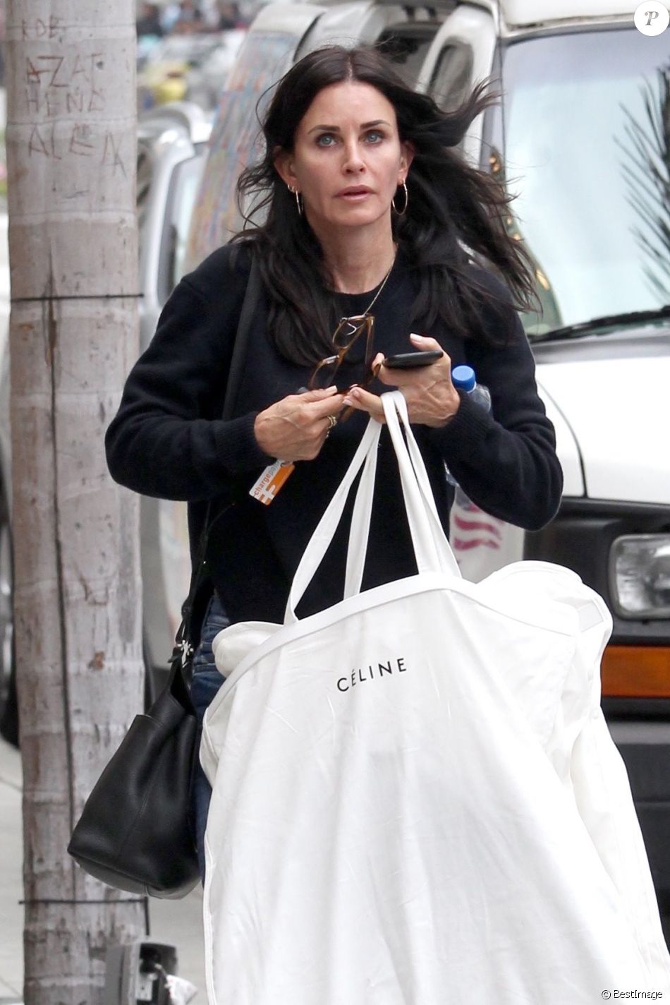 Exclusif - Courteney Cox porte une grande housse à vêtements de la