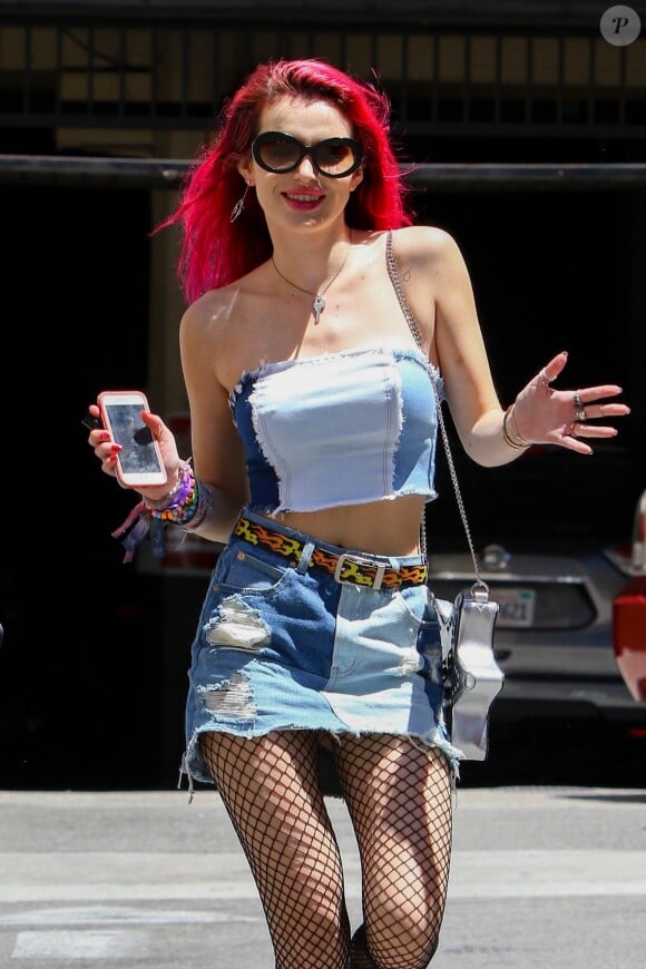 Bella Thorne se promène les cheveux rouges, jupe en jean et collants résille dans le quartier de downtown à Los Angeles, le 27 juin 2017