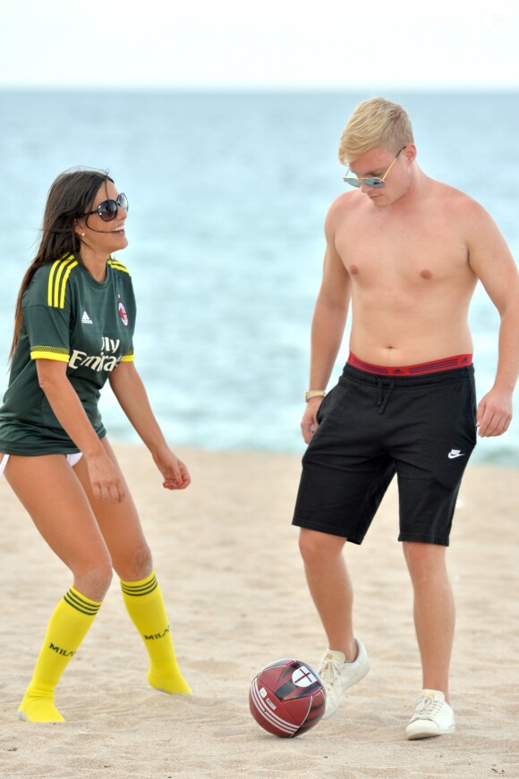Exclusif - Claudia Romani (Secret Story 9), vêtue du maillot du Milan AC et son compagnon Chris Johns jouent au foot sur la plage de Sunny Isles Beach le 19 juillet 2017.