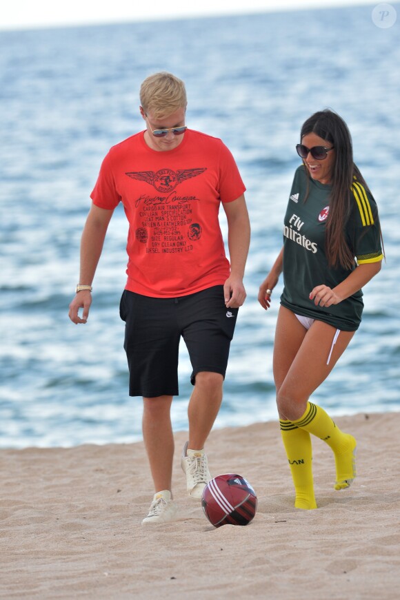 Exclusif - Claudia Romani (Secret Story 9), vêtue du maillot du Milan AC et son compagnon Chris Johns jouent au foot sur la plage de Sunny Isles Beach le 19 juillet 2017.