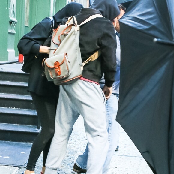 Taylor Swift et son compagnon Joe Alwyn se cachent des photographes à la sortie de son domicile à New York, le 24 juillet 2017