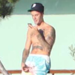 Exclusif - Justin Bieber passe la journée au bord d'une piscine avec son petit frère à Malibu. Justin discute et plaisante au téléphone alors que son petit frère se baigne dans la piscine et joue avec une énorme bouée en forme de cygne. Le 28 juillet 2017