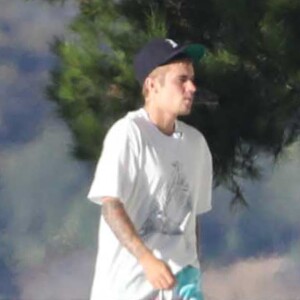 Exclusif - Justin Bieber passe la journée au bord d'une piscine avec son petit frère à Malibu. Justin discute et plaisante au téléphone alors que son petit frère se baigne dans la piscine et joue avec une énorme bouée en forme de cygne. Le 28 juillet 2017