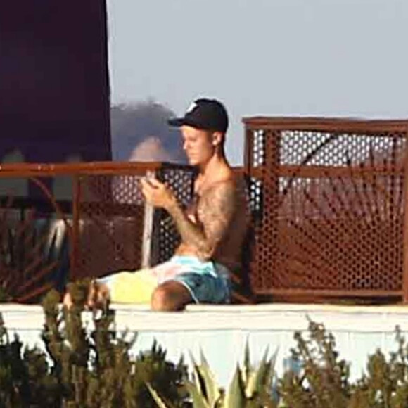 Exclusif - Justin Bieber passe la journée au bord d'une piscine avec son petit frère à Malibu. Justin discute et plaisante au téléphone alors que son petit frère se baigne dans la piscine et joue avec une énorme bouée en forme de cygne. Le 28 juillet 2017
