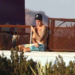 Exclusif - Justin Bieber passe la journée au bord d'une piscine avec son petit frère à Malibu. Justin discute et plaisante au téléphone alors que son petit frère se baigne dans la piscine et joue avec une énorme bouée en forme de cygne. Le 28 juillet 2017