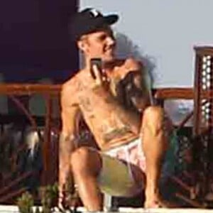 Exclusif - Justin Bieber passe la journée au bord d'une piscine avec son petit frère à Malibu. Justin discute et plaisante au téléphone alors que son petit frère se baigne dans la piscine et joue avec une énorme bouée en forme de cygne. Le 28 juillet 2017