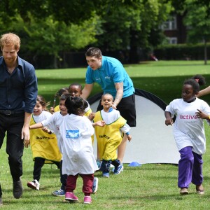 Le prince Harry joue avec des enfants lors de sa visite du centre de loisirs Newham Council's à Central Park à Londres, le 28 juillet 2017.