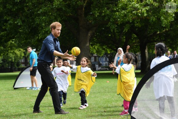 Le prince Harry joue avec des enfants lors de sa visite du centre de loisirs Newham Council's à Central Park à Londres, le 28 juillet 2017.