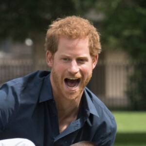 Le prince Harry joue avec des enfants lors de sa visite du centre de loisirs Newham Council's à Central Park à Londres, le 28 juillet 2017.