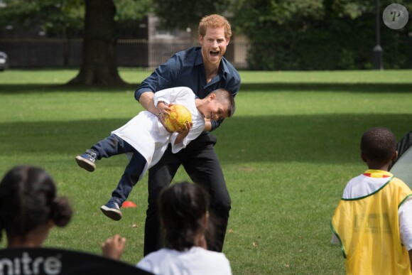 Le prince Harry joue avec des enfants lors de sa visite du centre de loisirs Newham Council's à Central Park à Londres, le 28 juillet 2017.