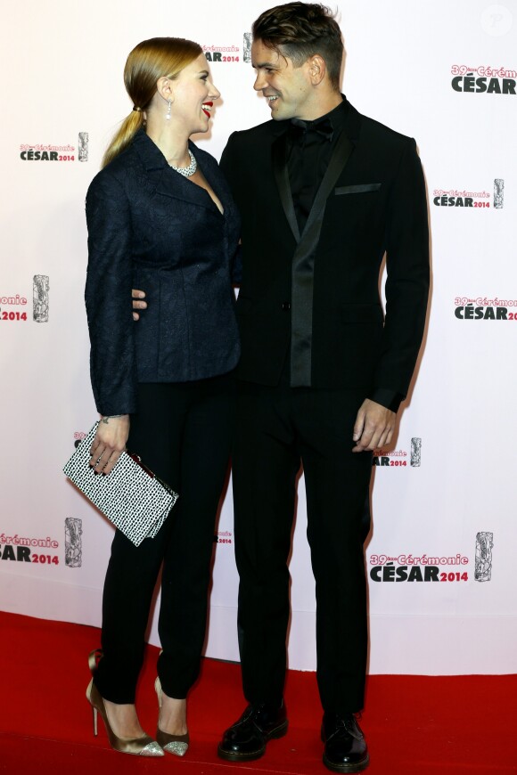 Scarlett Johansson (César d'honneur) (habillée avec une veste « Bar » en dentelle bleu marine, pantalon en crêpe de soie bleu marine et une pochette Dior) et Romain Dauriac - 39e cérémonie des César au théâtre du Châtelet à Paris Le 28 février 2014