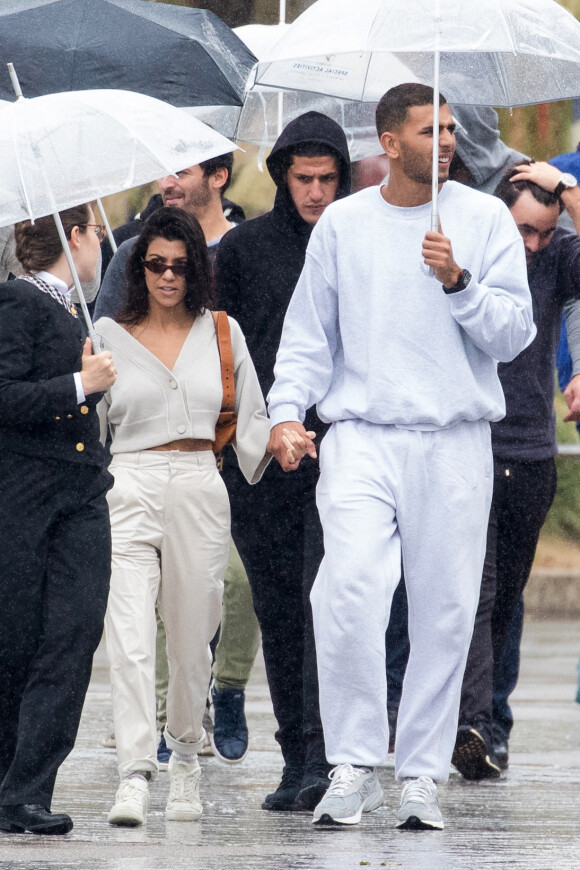 Exclusif - Kourtney Kardashian et son compagnon Younes Bendjima arrivent sous la pluie au Walt Disney Studio le 28 septembre 2017.