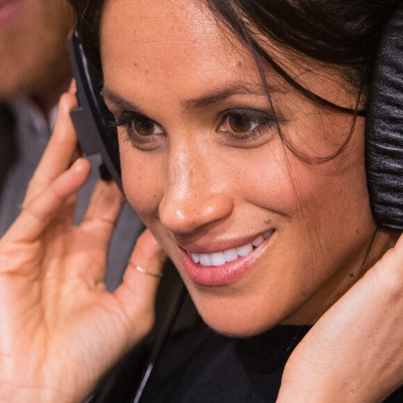 Le prince Harry et sa fiancée Meghan Markle écoutent une émission lors d'une visite à la station de radio Reprezent à Londres le 9 janvier 2018.