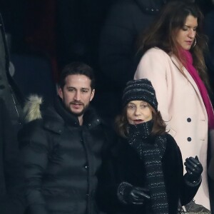 Isabelle Huppert et son fils Lorenzo Chammah (en arrière-plan, la secrétaire d'Etat Marlène Schiappa) dans les tribunes du Parc des Princes lors du match de Ligue 1 PSG - OM (3-0), à Paris le 25 février 2018.