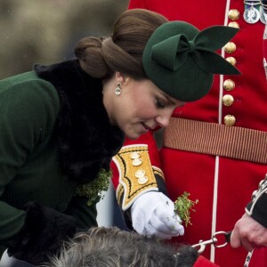 La duchesse Catherine de Cambridge, enceinte, offrant du chardon à la mascott Domhnall lors de la parade de la Saint Patrick à Houslow en présence du premier bataillon des gardes irlandais le 17 mars 2018.