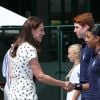 La duchesse Catherine de Cambridge (Kate Middleton) et la duchesse Meghan de Sussex (Meghan Markle) saluent le staff qui officiera lors de la finale dames, à Wimbledon le 14 juillet 2018, quelques dizaines de minutes avant le début de la finale opposant Serena Williams et Angelique Kerber.