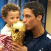 Raphaël Varane pose avec la Coupe du monde et son fils Ruben. Instagram, le 16 juillet 2018.
