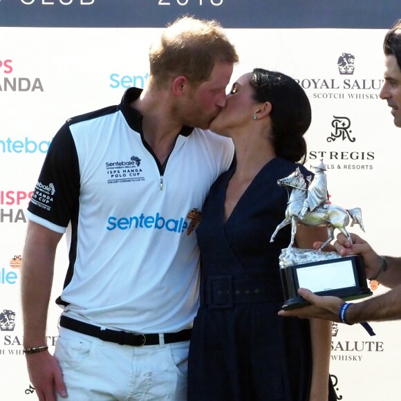 Le prince Harry, duc de Sussex, et Meghan Markle, duchesse de Sussex s'embrassent après la victoire de l'équipe du Duc à la coupe de polo ISP Hanes de Sentebale au Royal Berkshire Polo Club à Windsor au Royaume-Uni, le 26 juillet 2018.