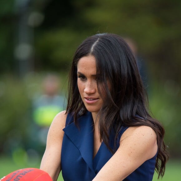 Meghan Markle s'essaye au rugby à la réception donnée par le gouverneur de Victoria à Melbourne le 18 octobre 2018.