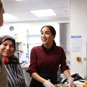 La duchesse Meghan de Sussex (Meghan Markle), enceinte et habillée d'une robe Club Monaco (et d'un tablier), a rencontré à nouveau les femmes de la Hubb Community Kitchen et cuisiné avec elles le 21 novembre 2018 au centre culturel Al Manaar dans North Kensington à Londres.