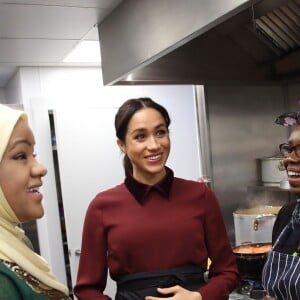 La duchesse Meghan de Sussex (Meghan Markle), enceinte et habillée d'une robe Club Monaco (et d'un tablier), a rencontré à nouveau les femmes de la Hubb Community Kitchen et cuisiné avec elles le 21 novembre 2018 au centre culturel Al Manaar dans North Kensington à Londres.