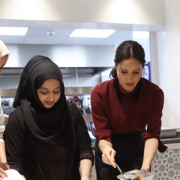 La duchesse Meghan de Sussex (Meghan Markle), enceinte et habillée d'une robe Club Monaco (et d'un tablier), a rencontré à nouveau les femmes de la Hubb Community Kitchen et cuisiné avec elles le 21 novembre 2018 au centre culturel Al Manaar dans North Kensington à Londres.