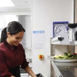 La duchesse Meghan de Sussex (Meghan Markle), enceinte et habillée d'une robe Club Monaco (et d'un tablier), a rencontré à nouveau les femmes de la Hubb Community Kitchen et cuisiné avec elles le 21 novembre 2018 au centre culturel Al Manaar dans North Kensington à Londres.