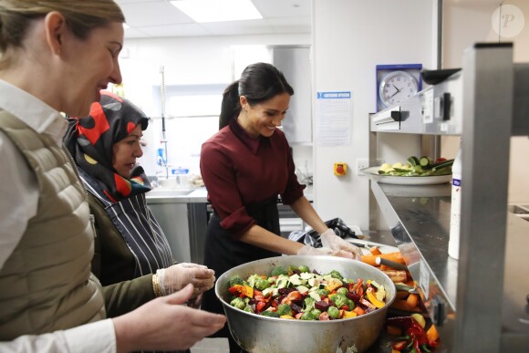 La duchesse Meghan de Sussex (Meghan Markle), enceinte et habillée d'une robe Club Monaco (et d'un tablier), a rencontré à nouveau les femmes de la Hubb Community Kitchen et cuisiné avec elles le 21 novembre 2018 au centre culturel Al Manaar dans North Kensington à Londres.