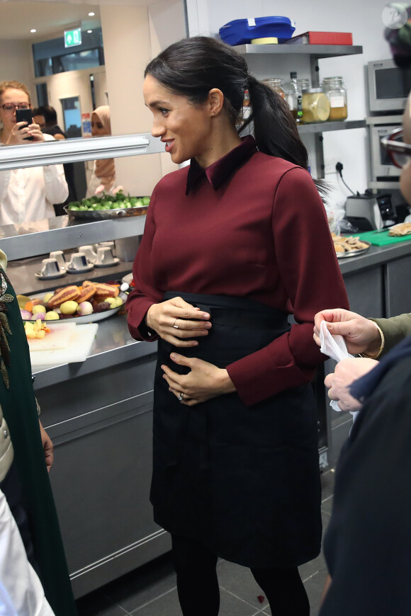 La duchesse Meghan de Sussex (Meghan Markle), enceinte et habillée d'une robe Club Monaco (et d'un tablier), a rencontré à nouveau les femmes de la Hubb Community Kitchen et cuisiné avec elles le 21 novembre 2018 au centre culturel Al Manaar dans North Kensington à Londres.