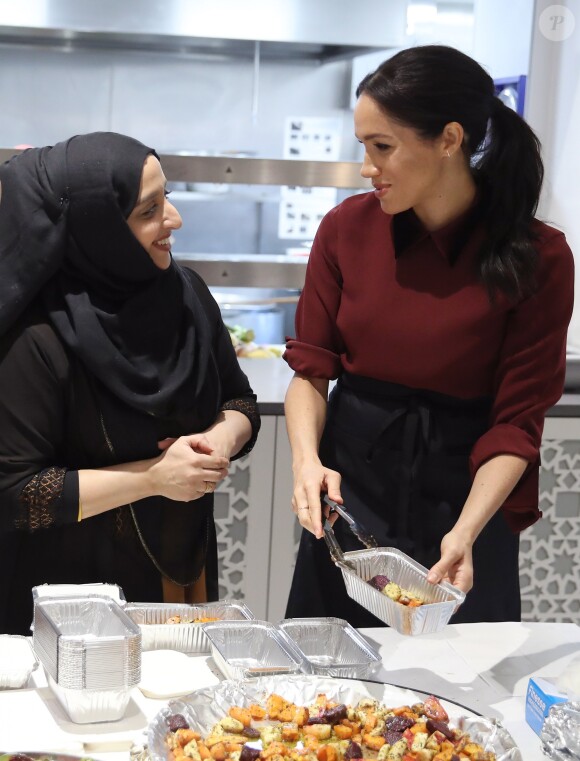 La duchesse Meghan de Sussex (Meghan Markle), enceinte et habillée d'une robe Club Monaco (et d'un tablier), a rencontré à nouveau les femmes de la Hubb Community Kitchen et cuisiné avec elles le 21 novembre 2018 au centre culturel Al Manaar dans North Kensington à Londres.