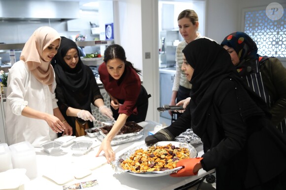 La duchesse Meghan de Sussex (Meghan Markle), enceinte et habillée d'une robe Club Monaco (et d'un tablier), a rencontré à nouveau les femmes de la Hubb Community Kitchen et cuisiné avec elles le 21 novembre 2018 au centre culturel Al Manaar dans North Kensington à Londres.
