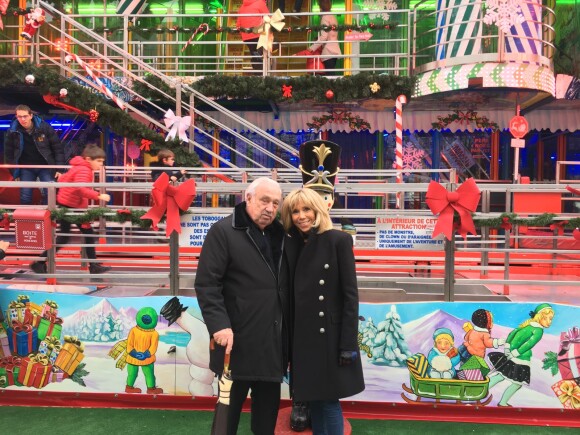 Brigitte Macron posant avec Marcel Campion lors d'une visite privée avec ses sept petits-enfants au marché de Noël des Tuileries à Paris le 23 décembre 2018.