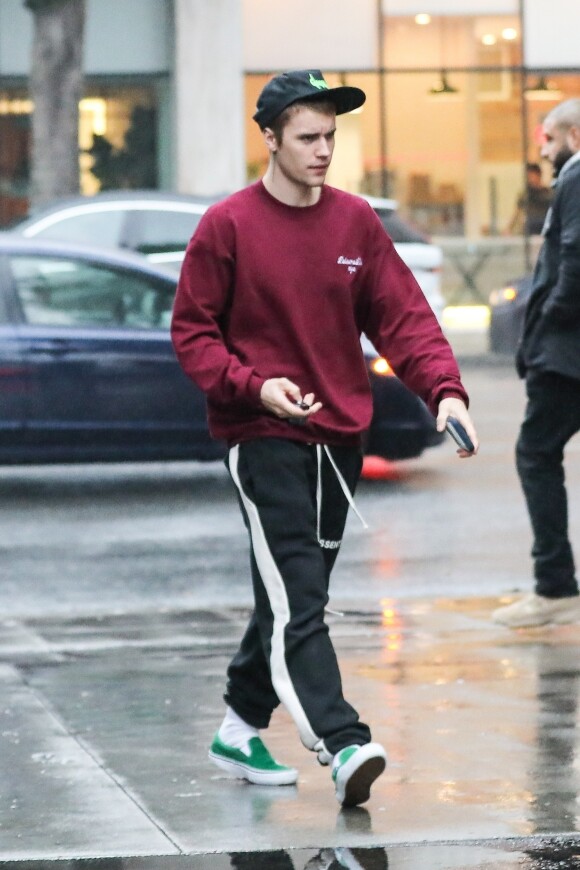 Justin Bieber arrive sous la pluie au restaurant Mainland Poke accompagné de son garde du corps à Beverly Hills, Los Angeles, le 16 janvier 2019