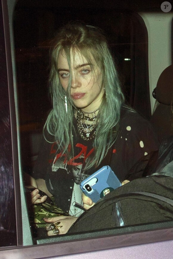 Exclusif - A la suite de son concert, Billie Eilish et sa mère M.Baird quittent la salle du Shepherd's Bush Empire à 00h45. Une équipe de tournage les rejoint à l'arrière de la voiture. Fière de sa fille, Maggie a collé un autocollant à l'effigie de Billie au dos de son téléphone. Billie porte un t-shirt Easy-E. Le chanteur de pop S.Smith a également assisté au concert de la chanteuse, il a quitté la salle à 23h40. Récemment le nouveau single de Billie "Wish You Were Gay" a déclenché une tempête de Twitts au sein de la communauté LGBTQ. A la suite de quoi elle a précisé "Cela veut littéralement dire que j'aurais préféré qu'il soit gay afin qu'il ne m'aime pas pour une vrai raison, plutôt qu'il ne m'aime pas parce qu'il ne m'aime pas. " Certains utilisateurs de Twitter n'ont pas été surpris d'apprendre que le single n'étais pas un hymne gay. Londres le 6 Mars 2019