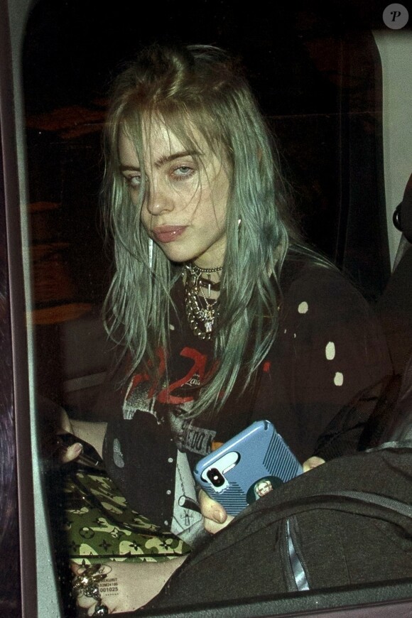 Exclusif - A la suite de son concert, Billie Eilish et sa mère M.Baird quittent la salle du Shepherd's Bush Empire à 00h45. Une équipe de tournage les rejoint à l'arrière de la voiture. Fière de sa fille, Maggie a collé un autocollant à l'effigie de Billie au dos de son téléphone. Billie porte un t-shirt Easy-E. Le chanteur de pop S.Smith a également assisté au concert de la chanteuse, il a quitté la salle à 23h40. Récemment le nouveau single de Billie "Wish You Were Gay" a déclenché une tempête de Twitts au sein de la communauté LGBTQ. A la suite de quoi elle a précisé "Cela veut littéralement dire que j'aurais préféré qu'il soit gay afin qu'il ne m'aime pas pour une vrai raison, plutôt qu'il ne m'aime pas parce qu'il ne m'aime pas. " Certains utilisateurs de Twitter n'ont pas été surpris d'apprendre que le single n'étais pas un hymne gay. Londres le 6 Mars 2019