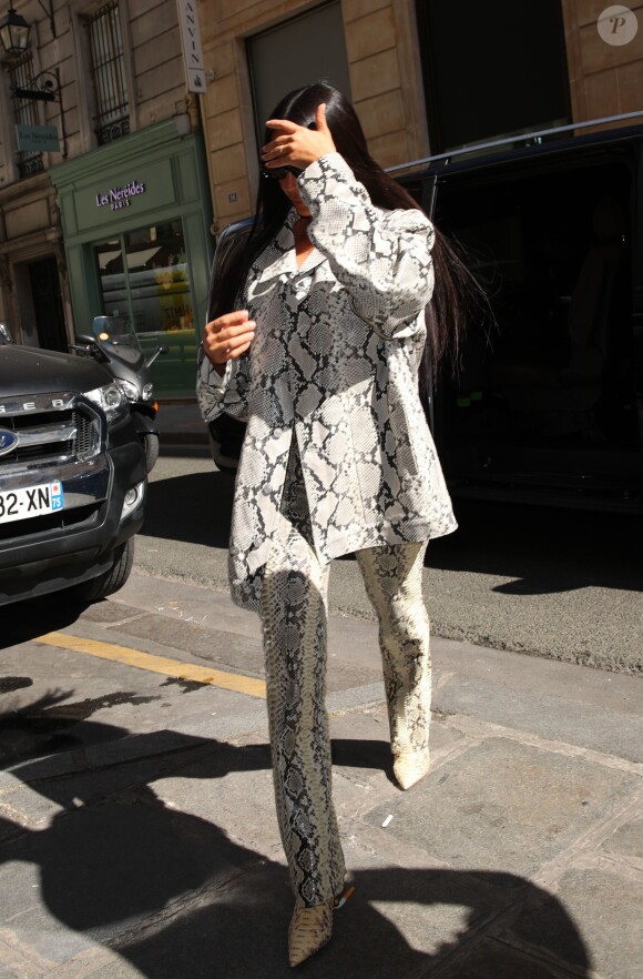 Kim Kardashian arrive chez Hermès à Paris le 25 mars 2019. Elle porte un ensemble motif python.